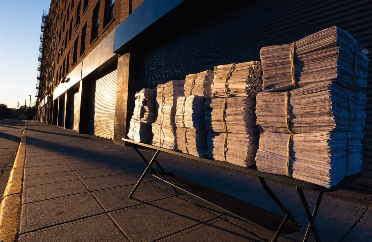 A quiet Brooklyn street at first light with long shadows and warm window glow