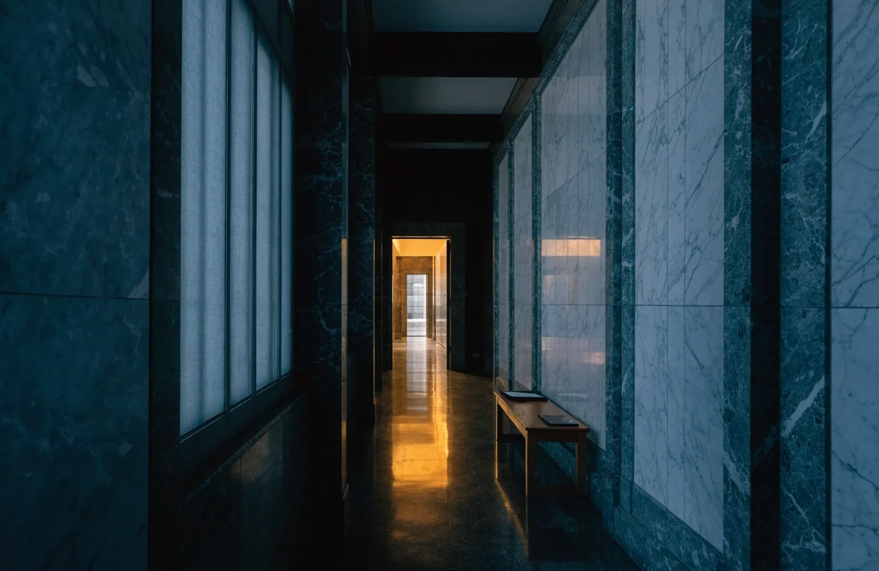 Empty conference room under a single pendant light with closed folders and pushed-in chairs