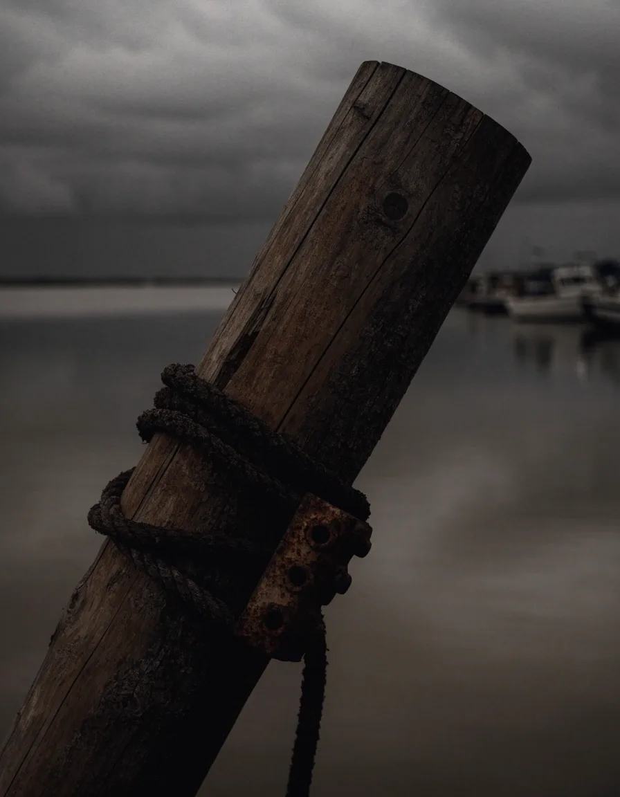 Gulf Coast marina at dusk with empty slips and tied-down boats under a dark westward sky